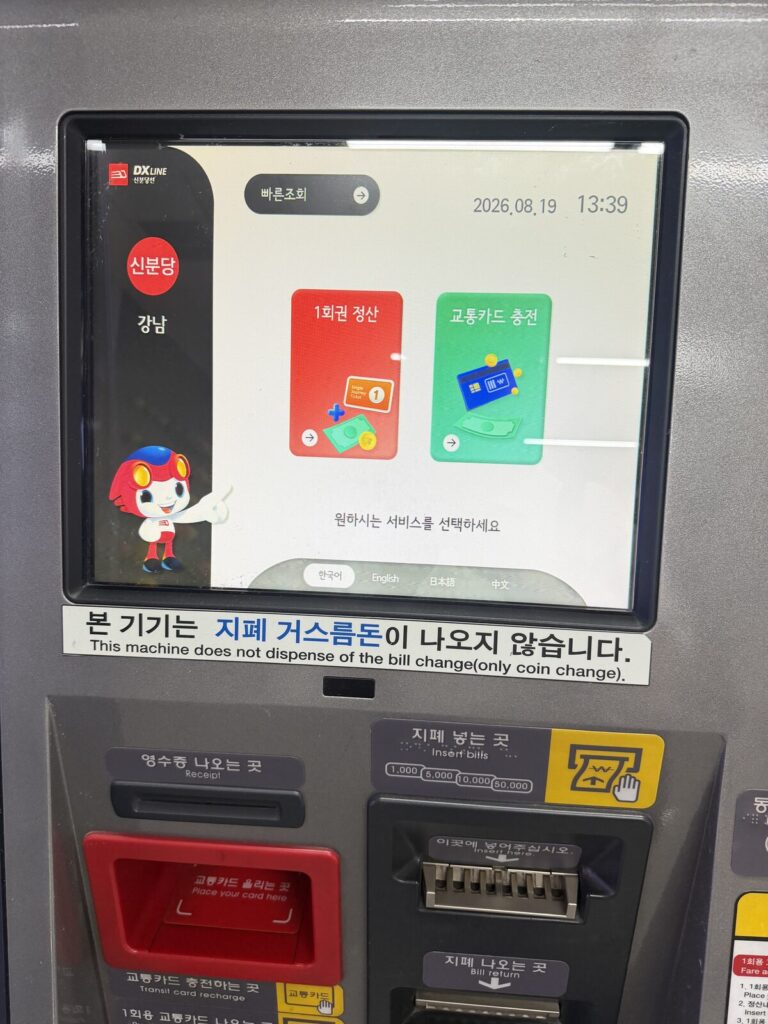 Close-up of a subway ticket machine touchscreen showing single-journey ticket and transit card recharge options in multiple languages
