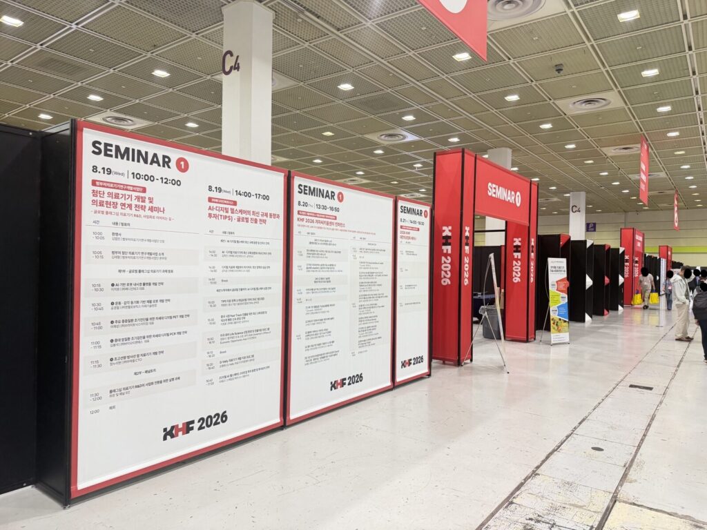 Entrance corridor to the KHF 2026 seminar halls at COEX with schedule boards lining the walls